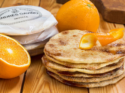 Andrés Gaviño Tortas mit Orange gestapelt auf Holz, daneben frische Orangen